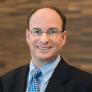 photo of a balding man with glasses and a blue shirt and tie